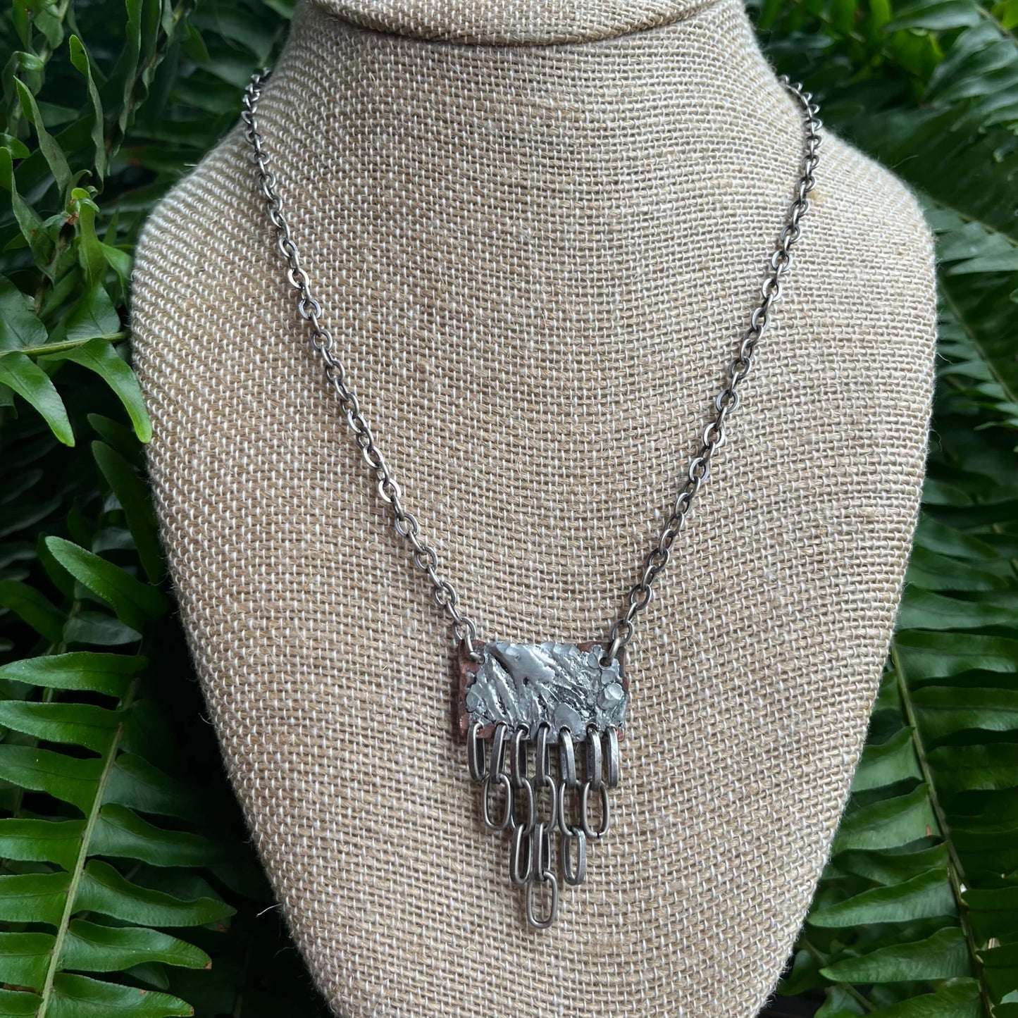 mixed metal necklace hanging on bust