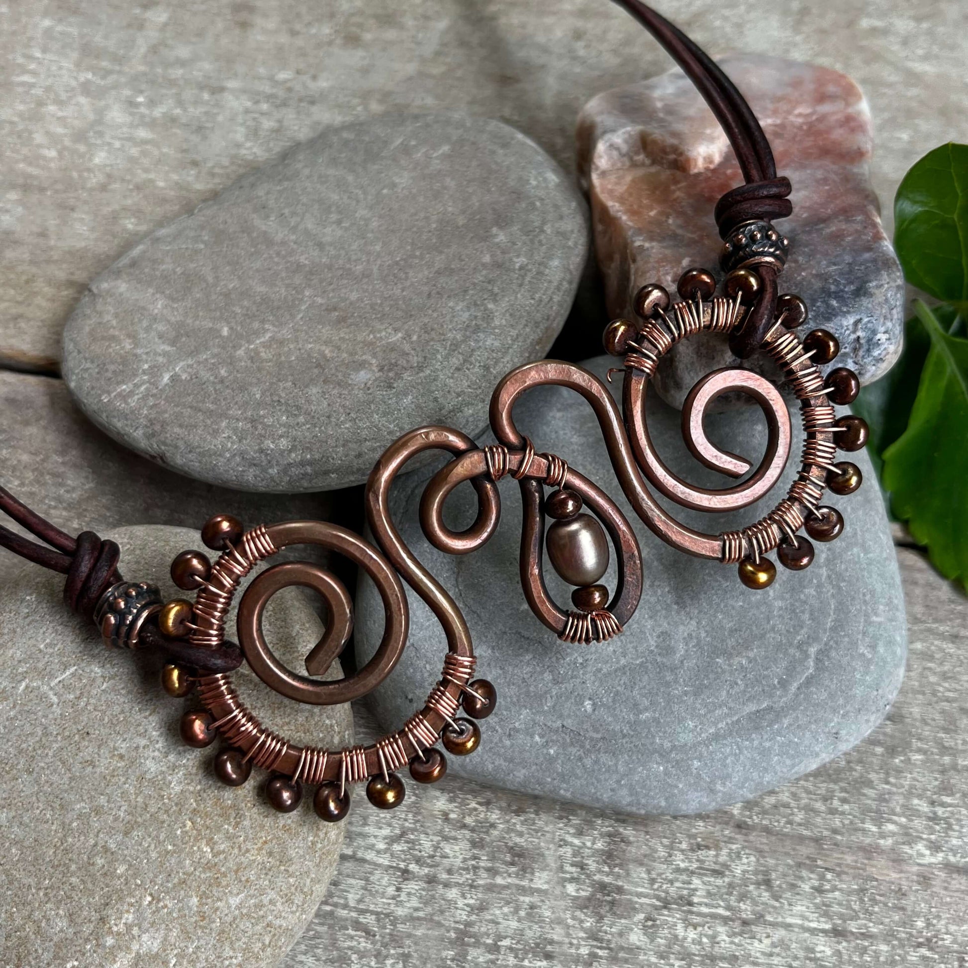 close up of copper swirl necklace with pearls