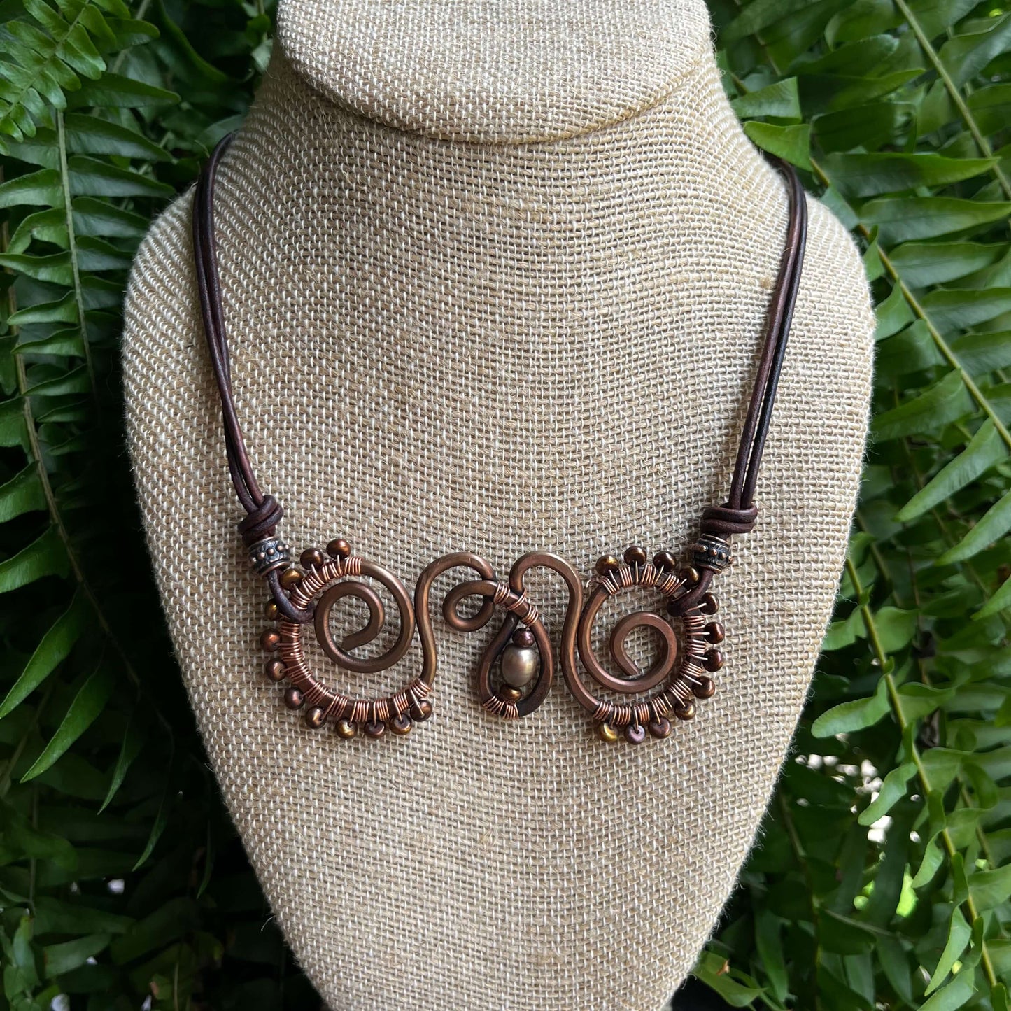 copper swirl with brown pearls displayed on bust