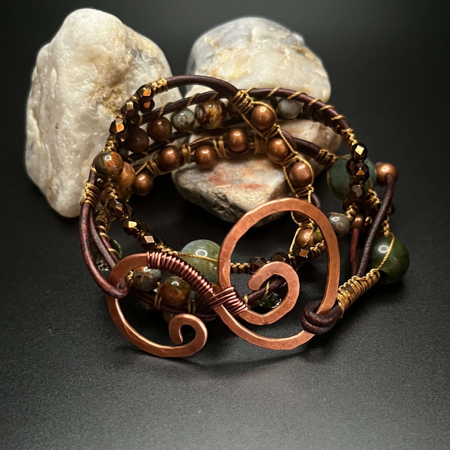 Triple Wrap Beaded Bracelet with Swirl closure  on stack of rocks