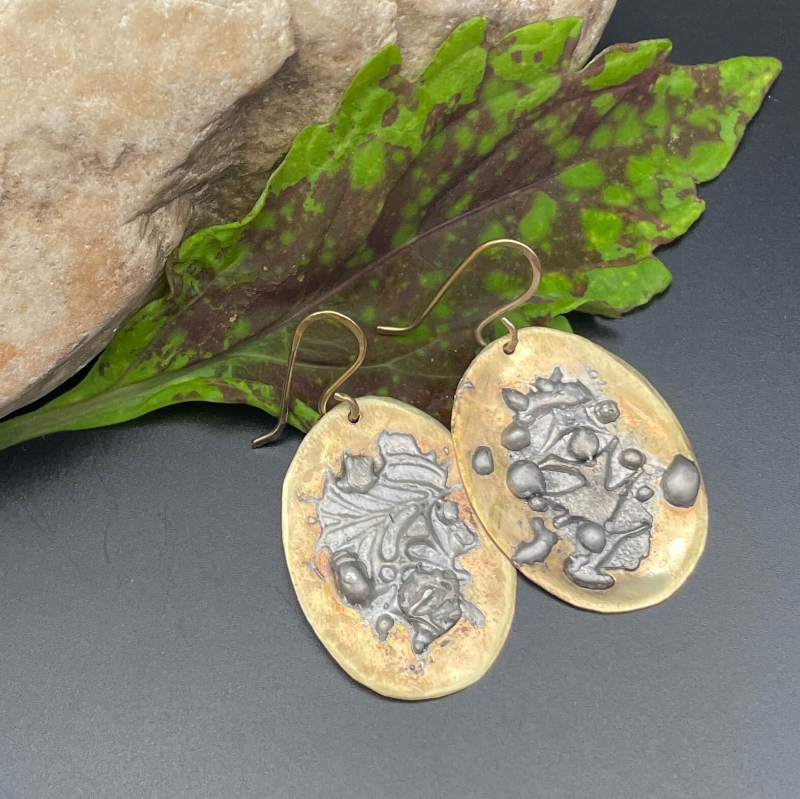 mixed metal earrings on leaf and rock