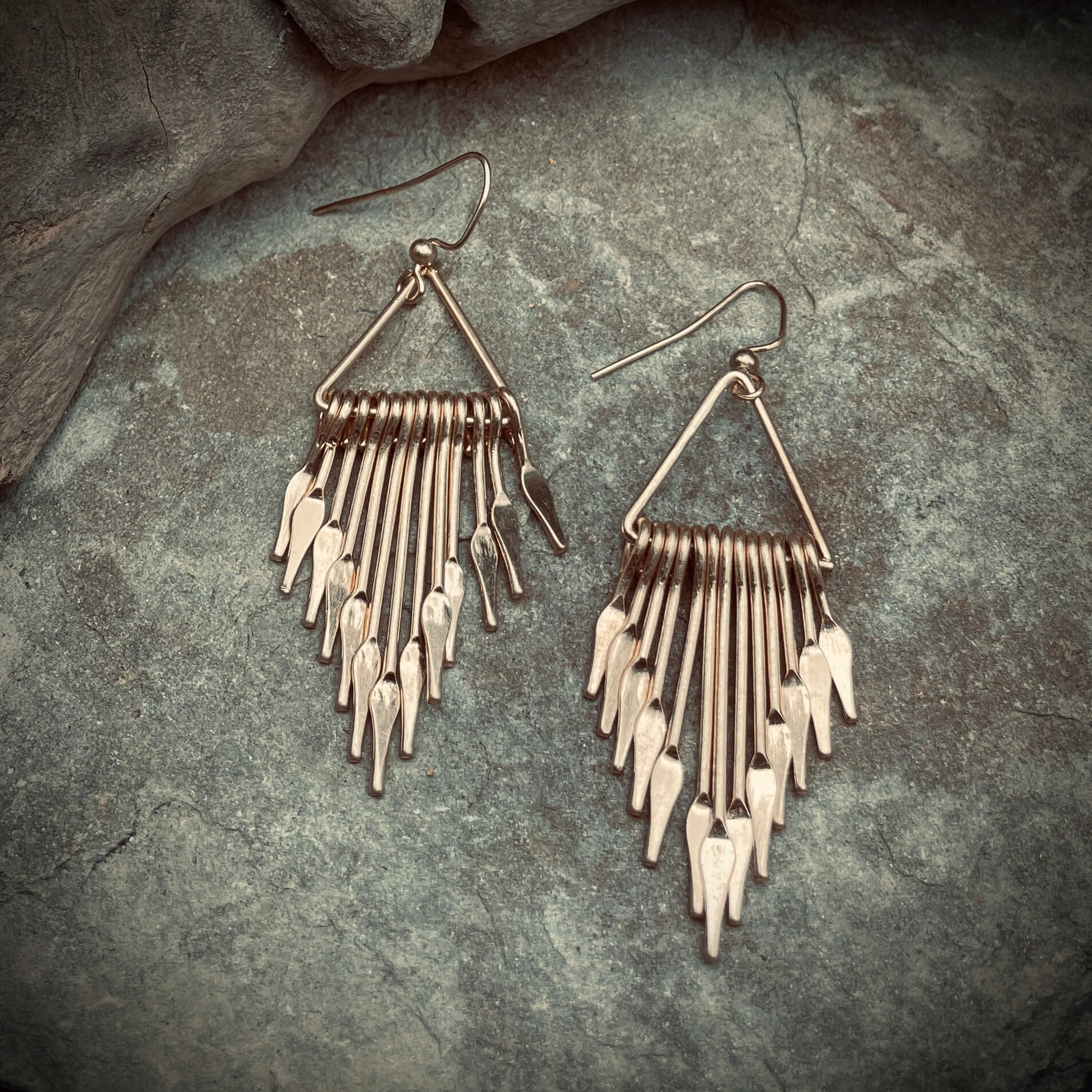 Brass fringe Earrings on rock