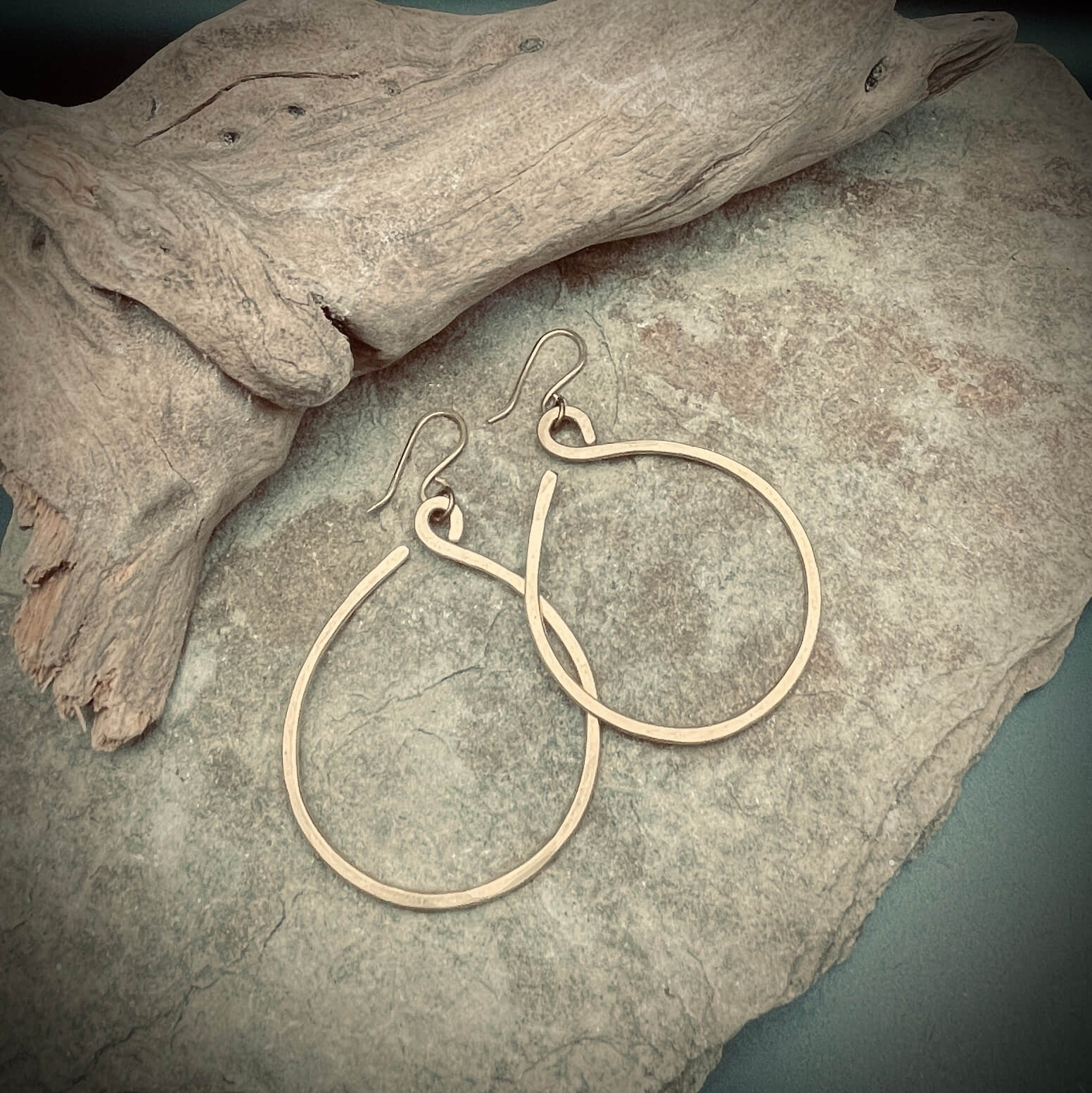 Brass Hoop Earrings on rock with drift wood