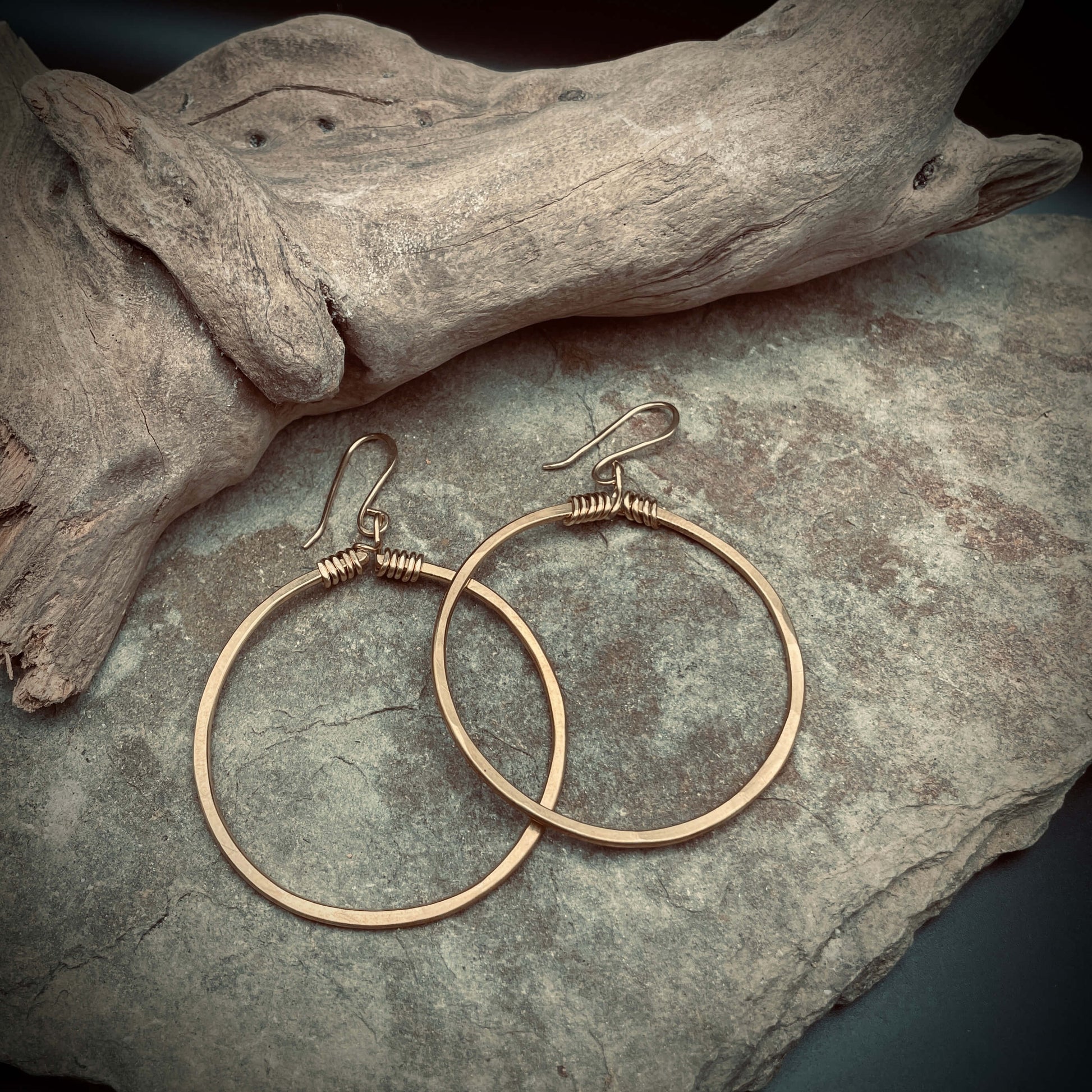 brass hoop earrings on rock